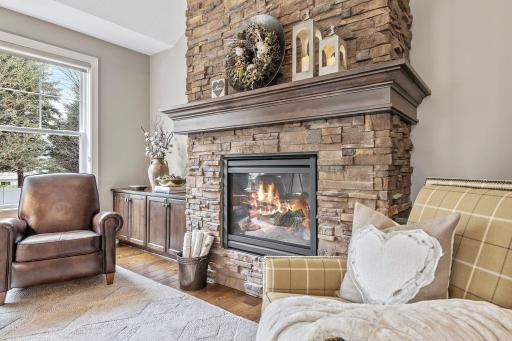 The living room features a cozy gas fireplace with floor to ceiling stone surround, creating an ambiance of warmth and comfort.