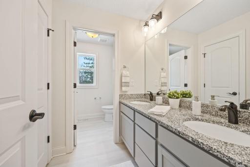 Upper full bath has dual sinks, linen closet and separate tub/toilet space.
