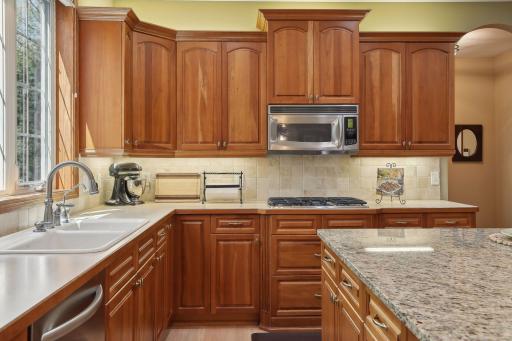 Custom details like fluted edges, triple window over sink and gas cooktop.