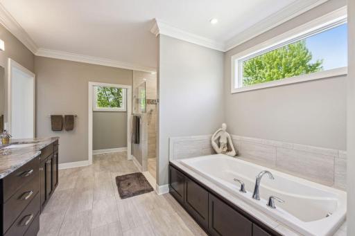 Large Soaking tub, double vanity sinks, walk-in tiled shower and separate stool area.