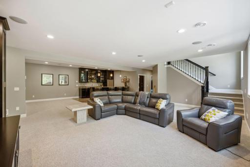 Spacious recreation area with room for a game table next to wet bar.
