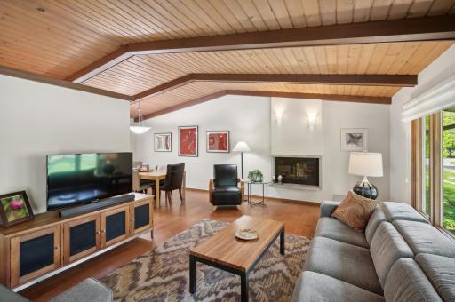 Original tongue and groove vaulted wood ceiling is accentuated by new luxury wood plank flooring. The home has a great mid-century flare.