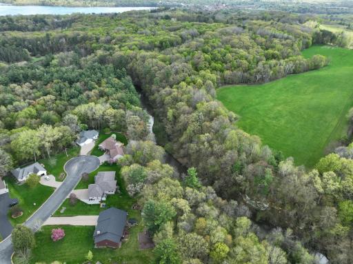 Nice drone shot showing the property located on a quiet cul de sac, the wooded backyard and creek located below.