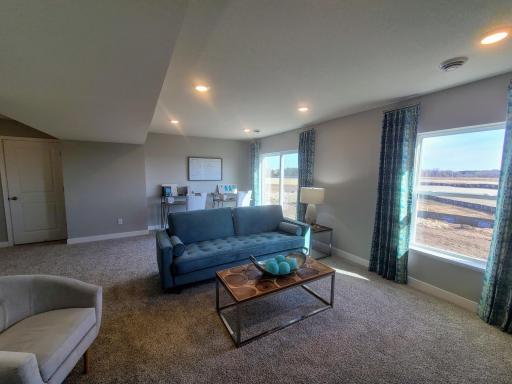 Once downstairs, the entire level flows from the focal point offered by this huge family room. Sure to become a family favorite hangout spot, the room is just steps from the lower level bedroom and bathroom! Photo is of actual home.
