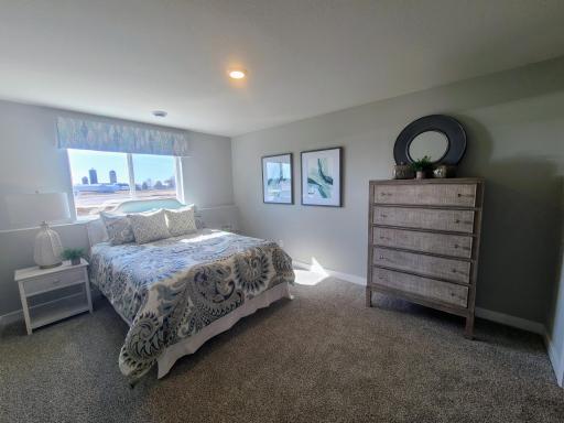 Tucked down in the lower level, and away from the hustle and bustle of the main level living spaces, this bedroom resides adjacent to a full bath and serves as the perfect guest room or your home office! Photo is of actual home.