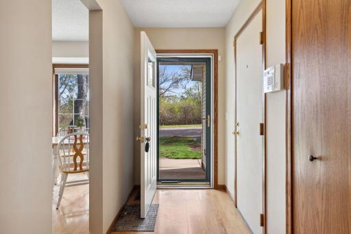 The glass storm door brings in natural light and views of Richfield Lake. On the right, see doors to hall closet and heated 2 car garage!