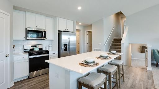 Extremely open and inviting, this main level is great for hosting or hanging out! Also, you can see the convenient main level bathroom nearby. Photo of Model Home. Options and colors may vary. Ask Sales Agent for details.