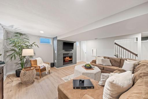 Cozy lower level family room with gas fireplace & kid's play nook with window under the stairs.