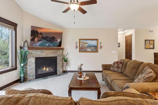 Living room with stone surround gas burning fireplace.