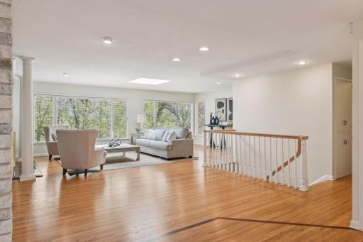 The open floor plan and expansive windows flood the living space with beaming light.