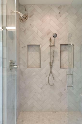 Beautifully tiled shower with glass doors.