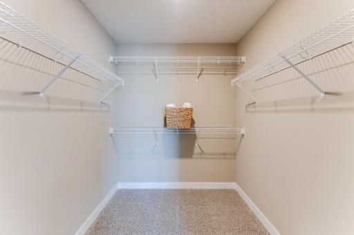 The primary bedroom's huge walk-in closet; plenty of room for all your clothes! Photo is of model - colors may vary.