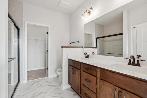The primary bathroom offers a dual vanity and full tile step-in shower.