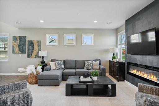 The lovely living room features large windows with plenty of natural light and an electric fireplace! *Photos of model home; colors and finishes will vary.