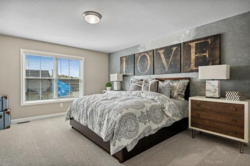 The private primary suite boasts an abundance of natural light. *Photos of model home; colors and finishes will vary.