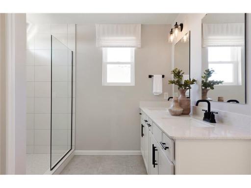Perfectly located off the bedroom is the Primary Bathroom. This bathroom features modern finishings such as white cabinetry with quartz countertops mixed with the comfort of your double sink vanity and roomy shower! Photo of model home.
