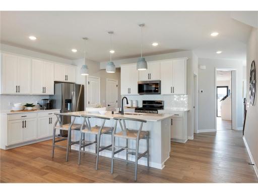 The Ashton also features modern white cabinets that complement the stainless-steel appliances perfectly! Photo of model home.