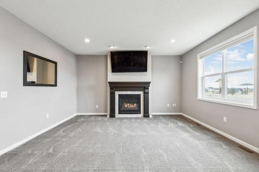 Relax in the cozy ambiance of the living room, featuring a charming gas fireplace for added warmth and comfort