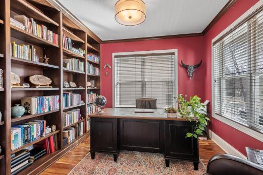 Adjacent to the living area is a den with a full wall of custom-built bookcases, making it an ideal space for a home office or library.