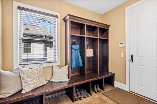 The mudroom provides functional storage with a bench, cubbies, and hangers.