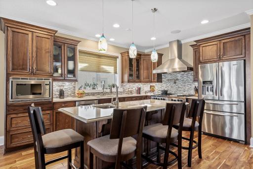 The gourmet kitchen is a chef's dream, boasting a 48-inch range with an indoor grill and hood, a double oven with convection, and a center island with breakfast bar seating.
