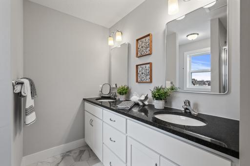 Private primary ensuite bathroom boasting dual sinks and walk-in shower.