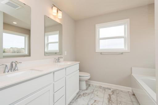 Relax in your private oasis, the owner's bath features a double-vanity and soaking tub