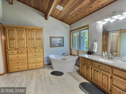 Absolutely stunning! The private primary bathroom is the ideal space to relax in the free-standing soaking tub.