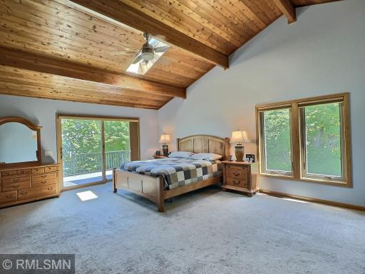 This magnificent primary bedroom is a retreat all on its own featuring vaulted ceiling with a skylight and fan.