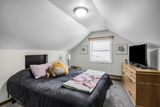 Upper Level Secondary Bedroom with two barn doors for additional storage space separate from the closet with cathedral ceiling