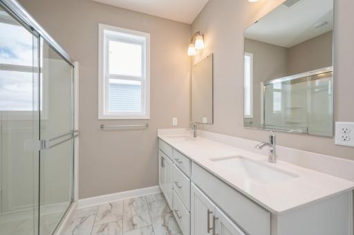 (*Photo of similar home, actual homes colors and finishes will vary) An extension of the owner's suite, this private and spacious bath contains a double-vanity