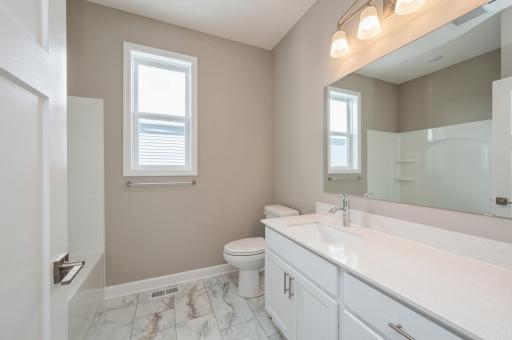 (*Photo of similar home, actual homes colors and finishes will vary) The spacious main level bath provides plenty of space for everyone to get ready during those busy mornings.