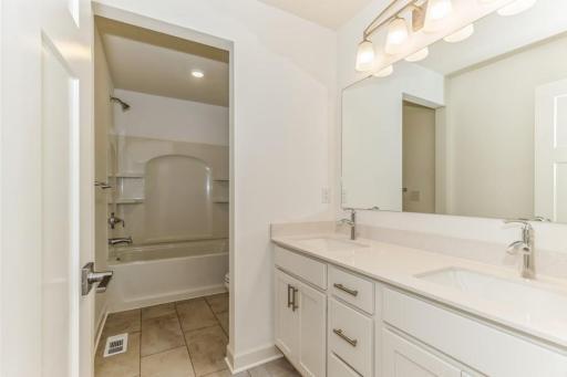 Photo is of the actual home. Featuring a double-vanity, this secondary bath is sure to keep everyone moving during those busy mornings.
