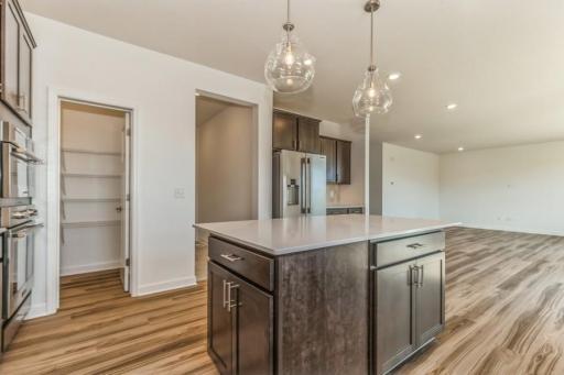 Photo is of the actual home. Enjoy plenty of seating at the kitchen island and dining area adjacent to the kitchen. Perfect for entertaining or having a family meal together.