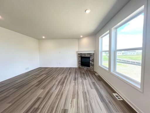 Photo is of the actual home. This modern fireplace with natural stone surround is an extraordinary room accent. Enjoy the warmth of this gas fireplace as you relax in your living room.