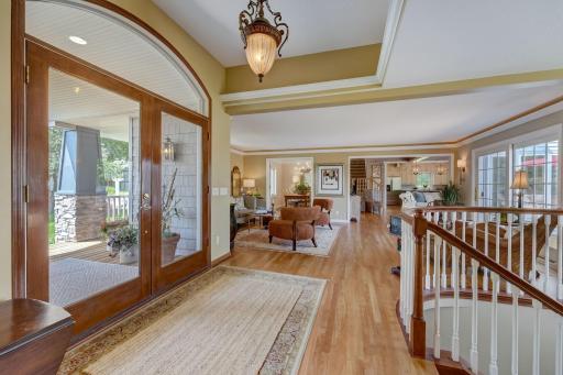 Bright Large Foyer and Open Floor Plan with Hardwood Flooring & Custom Curved Stair Railing