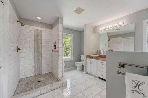 Primary Master Bathroom with walk-in shower, jetted jacuzzi tub, marble flooring, double vanities, lots of natural light, and 2 closets
