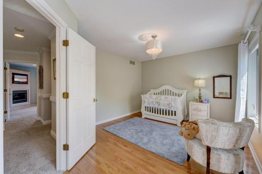 Bright and Inviting Large Nursery or Upper Bedroom with Hardwood Flooring