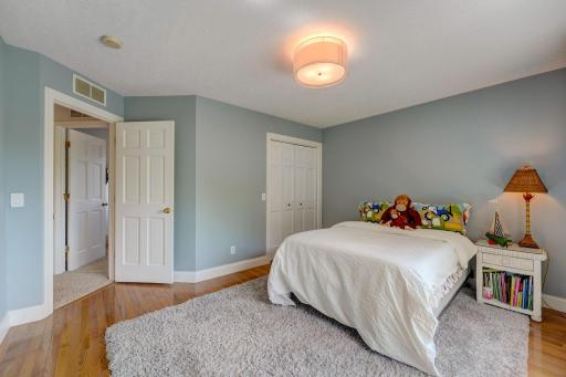 Bright and Inviting Large Upper Bedroom with Hardwood Flooring