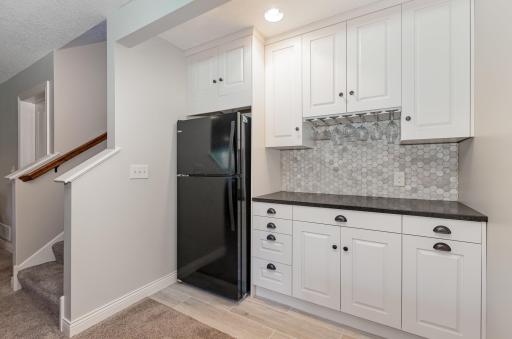 This lower-level "in-law" area offers convenience and comfort with its included refrigerator and cabinetry.