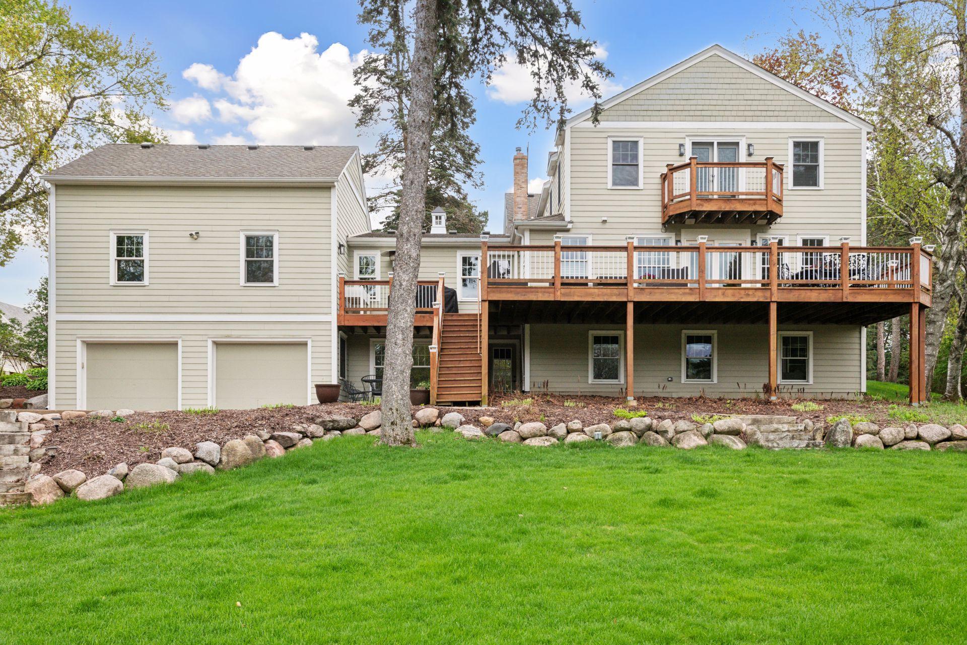 A stunning decking system with stairs to a lower patio offer outdoor livability and views of this expansive landscaped yard and a gorgeous pond.