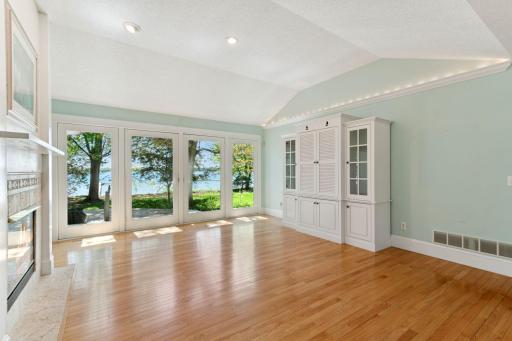 Commanding lake views from the Full Wall of Windows which open to the back yard. The custom built serving hutch, with interior lighting & pullout serving boards, will convey with the property.