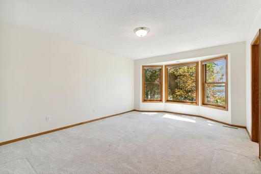 Generous size Lakeside Primary Bedroom with bay windows. The side split style home offers a wing of bedrooms away from the public rooms.