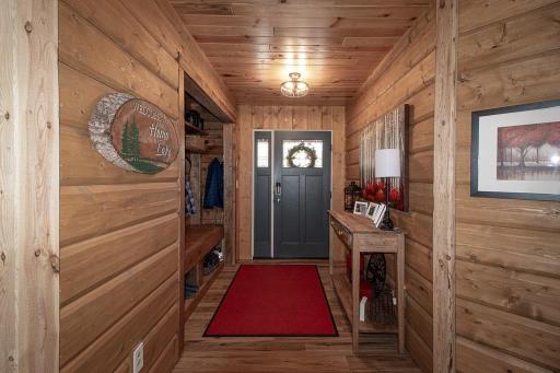 Enter the home to the fabulous 11x5 entryway which includes custom tree/mud room bench (to left). Most walls main floor are 2x10 hatchet hewn log siding! With hand-hewn 5x5 corners throughout.