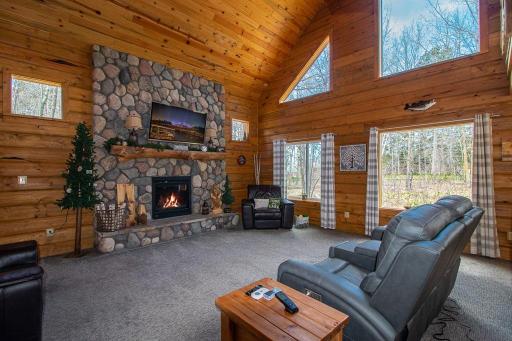 The entry opens to this warm & inviting Great Room! That is a real split river rock fireplace with Napolean gas insert and hand-split log mantle!