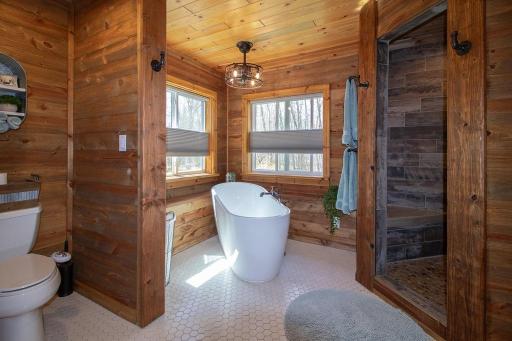 Roughly 11x11 Private Primary bath has custom built hickory cabinets & linen closet. Plus quartz countertop. Large free-standing soaker tub with built in surround/window bench!