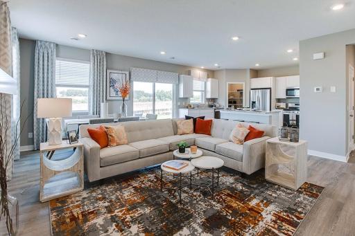 Large enough to accommodate just about any furniture set-up, the main level family room offers a great setting to relax in and flows seamlessly off both kitchen and dining areas! (Photo of model, colors are similar)