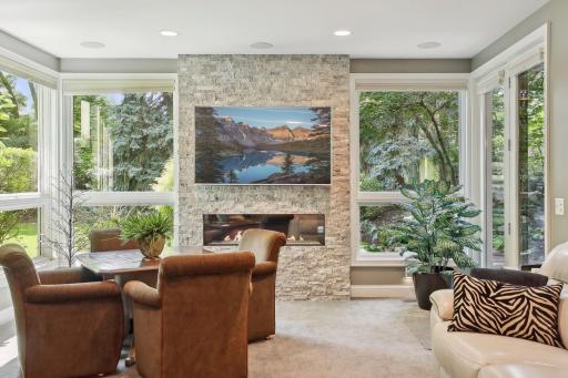 Stone fireplace with huge windows let nature in