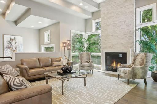 Living room with dramatic stone fireplace and unique walls of windows
