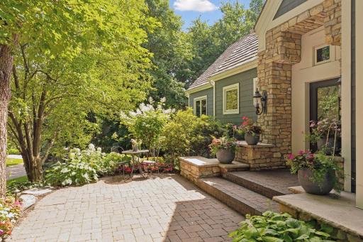 The front patio area is layered with flowering trees